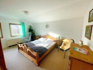 a bedroom with a wooden bed and a desk at Landhaus mit Pool, Bungalow in der Natur in Hohenbollentin +36 photos