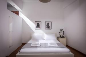 City Cave Apartment في مدينة هيراكيلون: غرفة نوم بيضاء بسرير ودرج