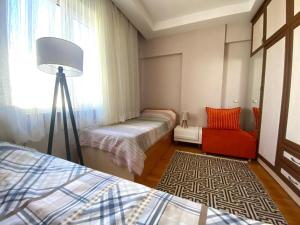 una camera con 2 letti, una lampada e una sedia di City Center a Antalya (Adalia)