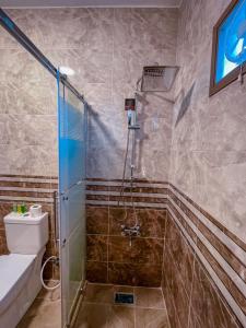 y baño con ducha y aseo. en Petra Caravan Guest House, en Wadi Musa