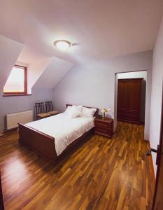 um quarto com uma cama grande e piso em madeira em Hincesti Hotel em Hînceşti