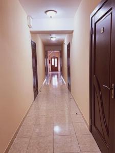 um corredor com portas e piso em azulejo num edifício em Hincesti Hotel em Hînceşti