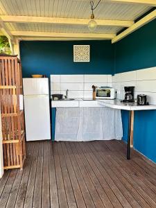 a kitchen with a refrigerator and a table in it at Bungalow vue mer avec jardin in Sainte-Luce