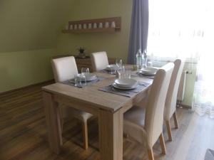 a wooden table with white chairs and a dining room at Wohlfühloase by Rent Rooms Rietz in Stein