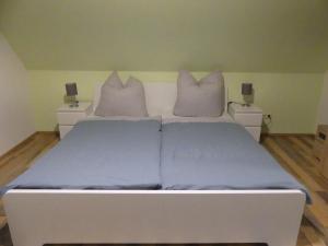 ein weißes Bett mit lila Bettwäsche und Kissen im Schlafzimmer in der Unterkunft Wohlfühloase by Rent Rooms Rietz in Stein bei Nürnberg