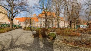 a park with a building and trees and a street at VacationClub - Old Town Apartament 12 in Kłodzko