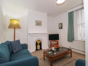 uma sala de estar com um sofá azul e uma lareira em Howard Cottage em Weymouth