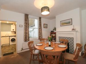 uma sala de jantar com uma mesa de madeira e cadeiras em Howard Cottage em Weymouth