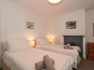 um quarto com 2 camas e uma lareira em Howard Cottage em Weymouth
