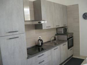 a kitchen with white cabinets and a sink at Civico10, appartamento centrale con parcheggio e terrazzo in Piombino