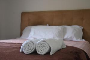 zwei Handtücher auf dem Bett in der Unterkunft Refúgio em Pelotas Com NF-E in Pelotas