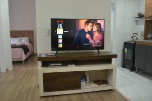 TV de pantalla plana en la mesa de la sala de estar en Refúgio em Pelotas Com NF-E en Pelotas