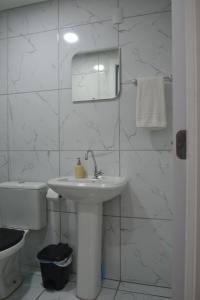 ein weißes Bad mit einem Waschbecken und einem WC in der Unterkunft Refúgio em Pelotas Com NF-E in Pelotas
