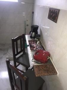 - une cuisine avec un comptoir avec une cuisinière et un sac rouge dans l'établissement Residencial Estrela Guia 1, à Cabo Frio