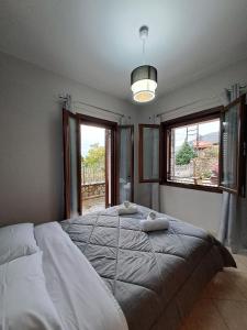 1 dormitorio con 1 cama grande y 2 ventanas en Kontolati's Mountain House, en Graviá
