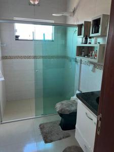 La salle de bains est pourvue d'une douche avec une porte en verre. dans l'établissement Casa Rondônia Rural show!, à Ji-Paraná