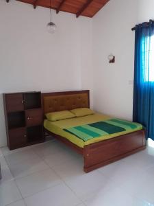 a bedroom with a bed and a dresser in a room at Unic Residence And Transit Hotel in Katunayake