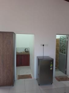 a kitchen with a stainless steel refrigerator and a counter at Unic Residence And Transit Hotel in Katunayake