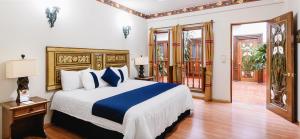 - une chambre dotée d'un grand lit avec des draps bleus et blancs dans l'établissement CASA MAYES, à Pátzcuaro