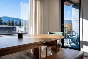 comedor con mesa y ventana grande en Snowed Inn - Stunning 3 Bedroom Condo en Revelstoke