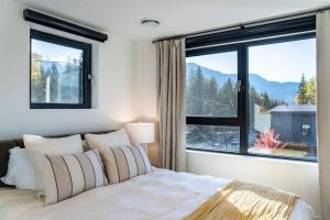 una camera da letto con un letto e una grande finestra di Snowed Inn - Stunning 3 Bedroom Condo a Revelstoke