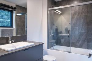 un bagno con doccia, lavandino e WC di Snowed Inn - Stunning 3 Bedroom Condo a Revelstoke Altre 23 foto