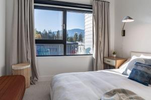 una camera da letto con un letto e una grande finestra di Snowed Inn - Stunning 3 Bedroom Condo a Revelstoke