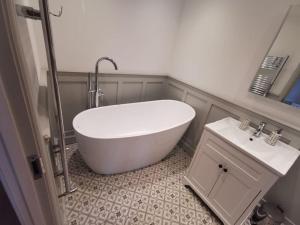 a bathroom with a white tub and a sink at No.12 - The Meadow in Banbury +15 photos