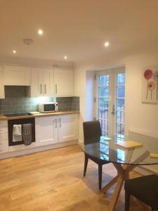 a kitchen with a dining room table and a kitchen with a counter at No.12 - The Meadow in Banbury