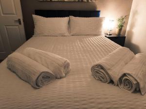 a bed with two pillows and towels on it at Contractors & Relocators Welcome! Leigh on sea Apartment - Free Parking! in Leigh-on-Sea