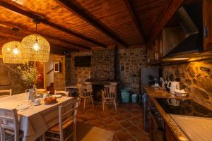 a kitchen and dining room with a table and chairs at Casa da Vila - Manteigas in Manteigas