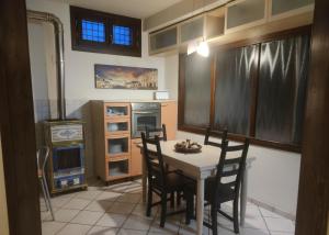 una cucina con tavolo, sedie e forno di La Dimora del Borgo a Pinerolo