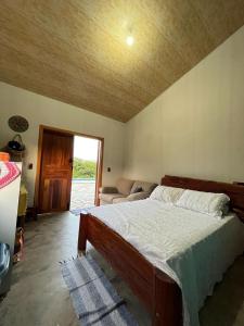 ein Schlafzimmer mit einem Bett und einem Sofa in einem Zimmer in der Unterkunft Estância Vista dos Pireneus in Pirenópolis