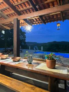 皮雷諾波利斯的住宿－Estância Vista dos Pireneus，一张木制野餐桌,享有游泳池的景色