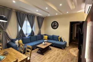 a living room with a blue couch and a table at جاكوزي وغرفة سينما شقه فاخرة في ممشى الهجرة VIP in Al Madinah