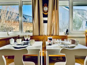 - deux tables et chaises blanches dans un restaurant avec fenêtre dans l'établissement Pension Ostsee-Strand, à Börgerende-Rethwisch