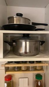 two pots and pans on a shelf in a kitchen at جاكوزي وغرفة سينما شقه فاخرة في ممشى الهجرة VIP in Al Madinah
