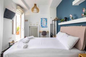 um quarto com uma grande cama branca e uma parede azul em Splendid view of Acropolis em Atenas