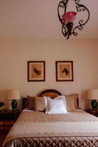 een slaapkamer met een bed met 2 lampen en een kroonluchter bij Linda casa 1h30 de SP dentro de HARAS com LAZER in Boituva