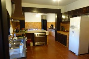 Il comprend une cuisine équipée d'un réfrigérateur blanc et d'une cuisinière. dans l'établissement Linda casa 1h30 de SP dentro de HARAS com LAZER, à Boituva