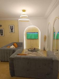 a living room with a couch and a tv at Résidences Hozy in Abidjan