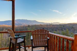 two chairs on a deck with a view of the mountains at New Luxe Cabin-Great Views, Pool, Hot Tub, Theater in Sevierville