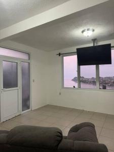 a living room with a couch and a large window at Casa Equipada con Vista Panorámica #1 in San Pedro La Laguna