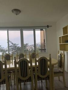mesa de comedor y sillas con mesa y ventanas en Casa Equipada con Vista Panorámica #1, en San Pedro La Laguna