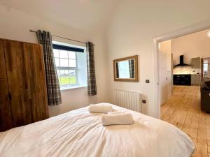 a bedroom with a bed with two towels on it at Modern Refurbished Church nr Butt of Lewis beaches in Port of Ness