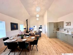 a dining room and kitchen with a table and chairs at Modern Refurbished Church nr Butt of Lewis beaches in Port of Ness