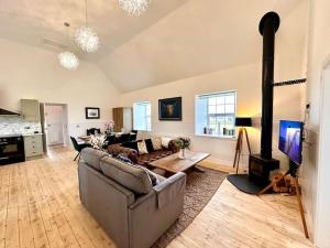 a living room with a couch and a wood stove at Modern Refurbished Church nr Butt of Lewis beaches in Port of Ness