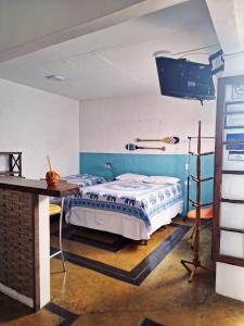 - une chambre avec un lit, un bureau et une télévision dans l'établissement Apartamento Centro Histórico - Vila- Ilhabela, à Ilhabela