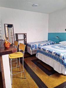 een slaapkamer met 2 bedden en een tafel en stoelen bij Apartamento Centro Histórico - Vila- Ilhabela in Ilhabela