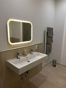 bagno con lavandino bianco e specchio di Luxusapartment Hamburg Hafencity ad Amburgo